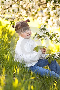 Tender girl near blooming apple tree branches
