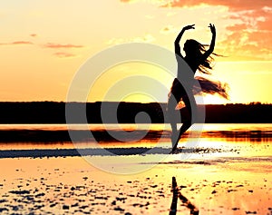 Tender girl young ballerina in pink transparent in a graceful jump on the lake