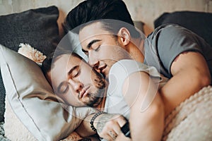 Positive delighted non-traditional couple sleeping together