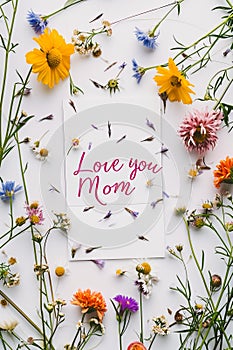 A tender handwritten Love You Mom message surrounded by vibrant flowers, expressing heartfelt sentiment