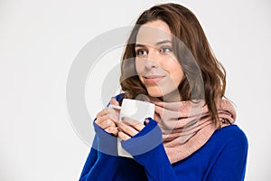 Tender happy woman in warm scarf drinking coffee from mug