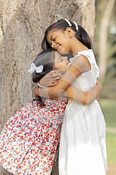 Tender little sisters hugging each other and showing their love