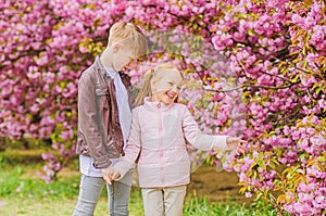 Tender love feelings. Little girl and boy. Romantic date in park. Spring time to fall in love. Kids in love pink cherry