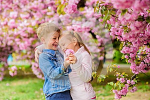 Tender love feelings. Little girl enjoy spring flowers. Giving all flowers to her. Surprising her. Kids enjoying pink