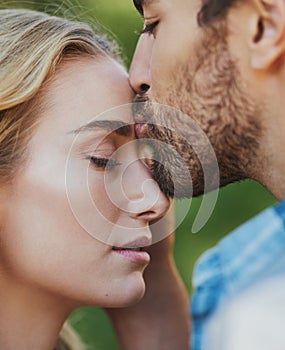 Tender loving kisses that melt the heart. an affectionate young couple having a romantic moment outdoors.