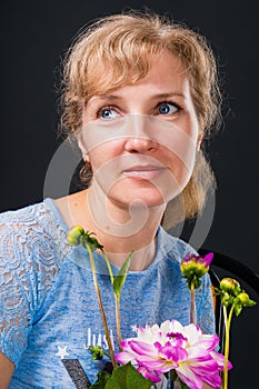 Tender pensive woman 45 years old with flowers