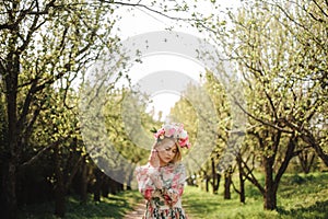 Tender portrait of beautiful blonde woman dressed in flower dress and pink wreath