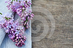 Tender purple lilac flowers on natural wooden background