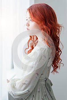 Tender retro portrait of a young beautiful dreamy redhead woman.