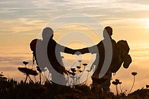 Tender silhouetted hikers at sunset