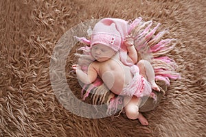 Tender sleeping newborn baby in pink cap