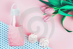 Tender tulip flowers and pink water bottle