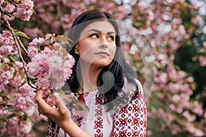 Tender woman touching pink flower in garden