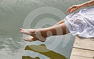Tender women`s feet on the river bank.