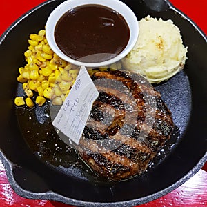 Tenderloin steak in blackpepper sauce with corn and mashed potatoes photo