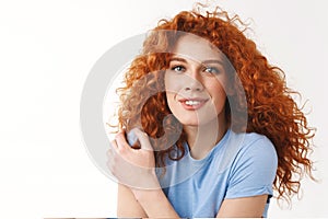 Tenderness, beauty and women concept. Alluring sensual young woman with reddish curly hair gently touching shoulder