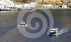 Tenders ferry passengers from cruise ship to  Santorini