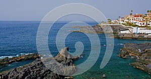 Tenerife, Canary Island, town with buildings Puerto de Santiago, Playa de Santiago. View of black rocky beach and