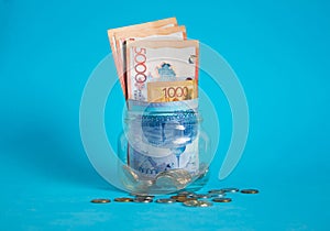 Tenge in a glass jar. Kazakhstan, KZ, KZT. Banknote, paper currency, coins, Bank. Salary, credit, savings, pay and spend. Business