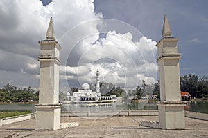 The Kuala Ibai Floating Mosque or Tengku Tengah Zaharah Mosque under heavy clouds as seen from lakeside pavilion in Terengganu, M photo