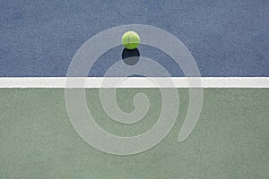 Tennis ball on blue and green hard court