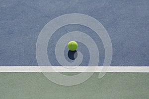 Tennis ball on blue and green hard court