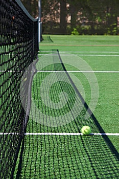 Tennis ball on a court neat net