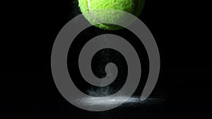 Tennis ball falling on black background