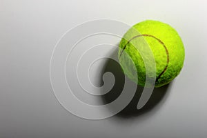 Tennis ball on grey background, close-up. Copyspace, textspace.
