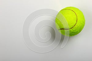 Tennis ball on grey background, close-up. Copyspace, textspace.