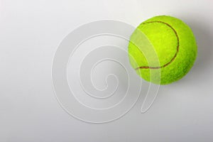 Tennis ball on grey background, close-up. Copyspace, textspace.