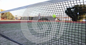 Tennis ball hit net after being hit in slow motion