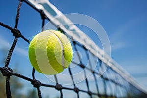 A tennis ball hitting a tennis court net