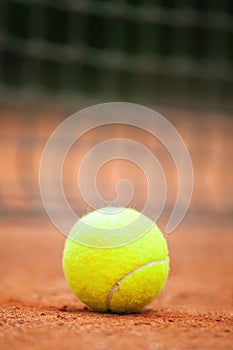 Tennis ball lies on the clay court close up