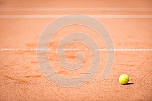 Tennis ball lying in orange sand