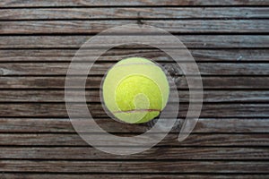 a tennis ball lying on wooden parquet