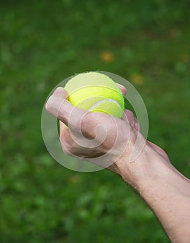 Tennis ball in man hand