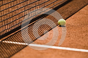 Tennis Ball and Net on a Clay Court