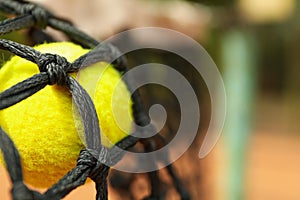 Tennis ball in net close up and space for text