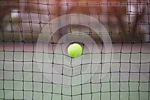 Tennis ball in net at tennis court