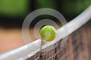 Tennis ball over net falls in the opponent's field