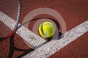 Tennis ball, racket and line on an outdoor court