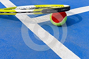 Tennis ball and racket in an outdoor court