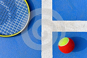 a tennis ball and racket in an outdoor court