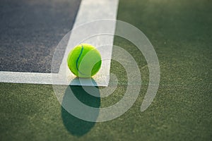 Tennis ball and racket under late evening sunlight