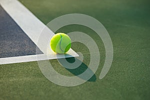 Tennis ball and racket under late evening sunlight