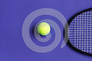 Tennis ball and racket. Violet background. Concept sport.