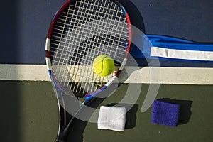 Tennis ball, racket, wristbands on tennis court