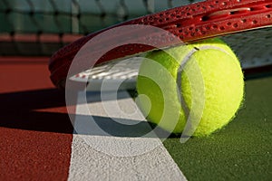 Tennis ball and racquet on a court