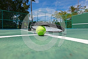 Tennis ball and racquet on court